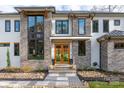 Inviting exterior showcasing a modern home with stone accents, custom double doors, and professionally landscaped front yard at 180 Willow Point Rd, Troutman, NC 28166