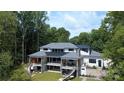 Expansive two-story home with multiple balconies, outdoor living spaces, and picturesque views of the surrounding greenery at 180 Willow Point Rd, Troutman, NC 28166