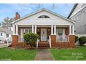 Inviting brick home with a cozy front porch, offering a glimpse of comfortable suburban living at 2125 Shenandoah Ave, Charlotte, NC 28205