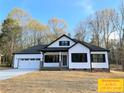 Beautiful home with white siding, a black roof, two-car garage, and a well-manicured lawn at 309 General As Johnston St, Stanley, NC 28164
