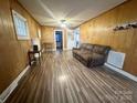 Inviting living room with a comfortable couch, and wood-look floors, offering ample space for relaxation and entertainment at 32341 Speiss Rd, Albemarle, NC 28001