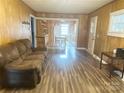 Cozy living room with a large window and wood-look floors, flowing into the adjacent kitchen and dining area at 32341 Speiss Rd, Albemarle, NC 28001
