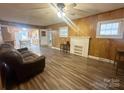 Bright living room showcasing wood-look floors, a decorative fireplace, and natural light from multiple windows at 32341 Speiss Rd, Albemarle, NC 28001