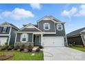 Charming two-story home with gray siding, stone accents, white trim, and an attached two-car garage at 330 Knotty Wood Dr # 67, Monroe, NC 28110