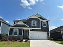 Charming two-story home features gray siding, white trim, a two-car garage, and a well-manicured lawn at 330 Knotty Wood Dr # 67, Monroe, NC 28110