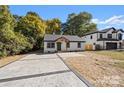 Newly renovated home with a new driveway, wooden porch and dark trim windows at 3717 Marvin Rd, Charlotte, NC 28211
