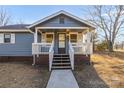 Inviting front entrance with a covered porch, white railings, and a concrete walkway at 445 Cannon Farm Rd, China Grove, NC 28023