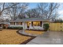 Newly renovated brick home with a walkway, fresh landscaping, and a modern fence at 4531 Rockford Ct, Charlotte, NC 28209