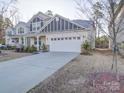View of the front exterior showcasing the home's driveway, landscaping and charming architectural details at 5028 Colline Ct, Charlotte, NC 28216