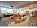 Open-concept living room and kitchen area featuring modern decor, hardwood floors, and abundant natural light at 5028 Colline Ct, Charlotte, NC 28216