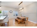 Open-concept dining area with modern light fixtures and a wooden table at 6503 Revolutionary Trl, Charlotte, NC 28217