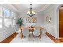 Bright dining room with hardwood floors, chandelier, and large windows with plantation shutters at 7029 Gardner Pond Ct, Charlotte, NC 28270