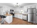 Modern kitchen featuring white cabinets, butcher block countertops, and stainless steel appliances at 717 Perth Rd, Troutman, NC 28166