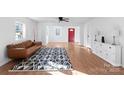 Bright living room featuring hardwood floors, a modern rug, and a red front door at 717 Perth Rd, Troutman, NC 28166