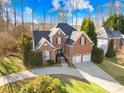 Attractive two-story brick home featuring manicured landscaping, a two-car garage, and a spacious driveway at 8020 Harrington Woods Rd, Charlotte, NC 28269