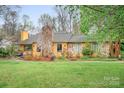 Inviting single Gathering home featuring a stone chimney, mature landscaping and a well-maintained lawn at 8133 Strawberry Ln, Charlotte, NC 28277