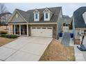 Well-manicured lawn with a two-car garage and trash receptacles along the side of the home at 105 Blossom Ridge Dr, Mooresville, NC 28117
