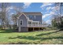 Backyard view of the two story home showcasing a spacious deck and expansive yard at 116 Rose Ter, Wadesboro, NC 28170