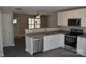 Modern kitchen featuring white cabinets, granite countertops, stainless appliances, and open access at 1410 Meadow Ave, Kannapolis, NC 28083