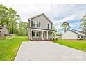 A two-story home features a gray exterior, black shutters, a welcoming front porch, and a spacious front yard at 1412 Meadow Ave, Kannapolis, NC 28083