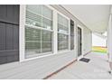 This is a close up of the gray front porch, black shutters, a black door, and ample natural light at 1412 Meadow Ave, Kannapolis, NC 28083