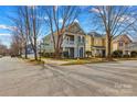 A charming two-story home with a porch and balcony sits on a corner lot in a neighborhood with sidewalks at 14462 Holly Springs Dr, Huntersville, NC 28078
