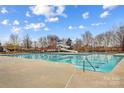Large outdoor pool and slide with clear blue water is ready for summer fun at 14462 Holly Springs Dr, Huntersville, NC 28078