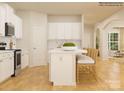 Open kitchen featuring white cabinets, an island with counter seating, and wood flooring at 1566 Croydon St, Indian Land, SC 29707