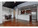 Open-concept living and kitchen area featuring stained concrete floors and industrial-style ceilings at 2338 Yadkin Ave # 205, Charlotte, NC 28205