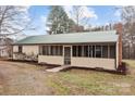 View of the side of the house featuring a screened porch and a metal roof in a rural area at 2845 Wood Gate Rd, Lincolnton, NC 28092