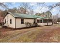 Exterior shot of house with green metal roof, shed, gravel driveway, and landscaped beds at 2845 Wood Gate Rd, Lincolnton, NC 28092