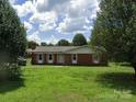 Charming single-story brick home with a well-maintained lawn and mature trees creating a peaceful and inviting curb appeal at 3003 Winston Nw Dr, Concord, NC 28027
