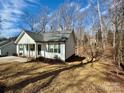Charming single-story home with white siding, a gray roof, and a spacious yard in a wooded neighborhood at 514 Meadowrock Dr, Albemarle, NC 28001