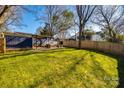 Large, green backyard featuring deck with outdoor seating and wood privacy fence at 119 N Smallwood Pl, Charlotte, NC 28216