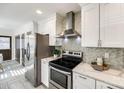 Modern kitchen with stainless steel appliances, white cabinets, and stylish backsplash at 119 N Smallwood Pl, Charlotte, NC 28216
