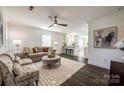 Bright living room with hardwood floors and neutral decor flows to the kitchen at 119 N Smallwood Pl, Charlotte, NC 28216