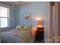 Comfortable bedroom with a bright window, a cozy quilt, and charming decor at 1284 Independence St, Tega Cay, SC 29708