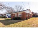 Exterior view of a brick home showcasing its side profile with well-maintained yard and landscaping at 132 Kennedy Ave, Kannapolis, NC 28083