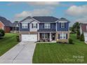 Beautiful home with an attached two-car garage, manicured lawn, and charming front porch decor at 137 Tenth Green Ct, Statesville, NC 28677