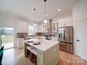 Bright, modern kitchen with stainless steel appliances, white cabinets, and a kitchen island with seating at 2511 Dundeen St, Charlotte, NC 28216