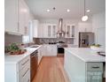 Well-lit kitchen featuring stainless steel appliances, white cabinets, stylish backsplash, and modern fixtures at 2511 Dundeen St, Charlotte, NC 28216