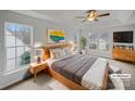 Sunlit main bedroom featuring tray ceiling, a ceiling fan, and large windows for plenty of natural light at 609 Sunset Point Dr, Rock Hill, SC 29732