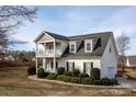 Charming two-story home with a covered porch, balcony, and beautiful landscaping at 662 Georgie St, Troutman, NC 28166