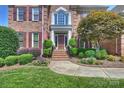 Inviting entryway with landscaped steps leading to a classic front door framed by manicured greenery at 9316 Whispering Wind Dr, Charlotte, NC 28277