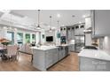 Open kitchen featuring gray cabinets, a large island with a sink, and stainless steel appliances, with living area at 1039 Rabbit Hill Ln, Monroe, NC 28110