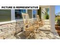 Inviting front porch featuring stone accents and comfortable rocking chairs for relaxing outdoors at 117 Noah Ln, Troutman, NC 28166