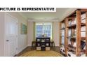 Bright office space with natural light, decorative shelving, and a cozy rug at 117 Noah Ln, Troutman, NC 28166