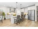 Modern kitchen featuring stainless steel appliances, white cabinets, and an island with bar seating at 12636 Twilight Dr, Mint Hill, NC 28227