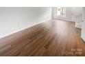 A bright, empty living room with laminate flooring, a door and a large window at 16837 Greenlawn Hills Ct, Charlotte, NC 28213