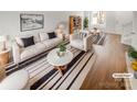 Bright, staged living room featuring modern furniture, a striped rug and wood floors at 16837 Greenlawn Hills Ct, Charlotte, NC 28213